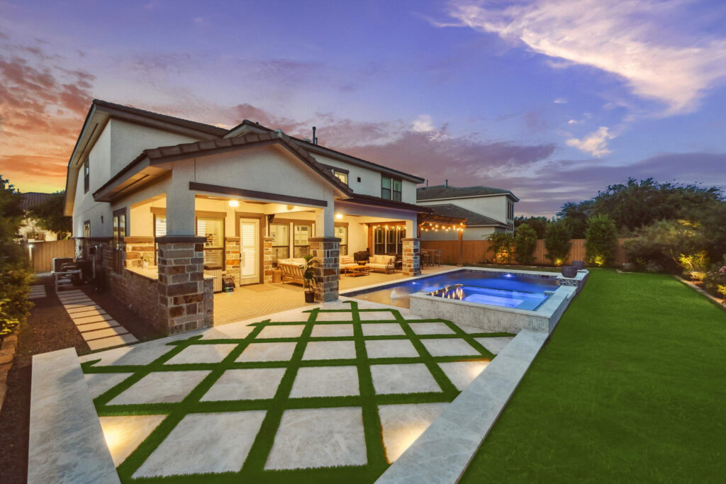 Custom pool with travertine pavers and covered patio at sunset